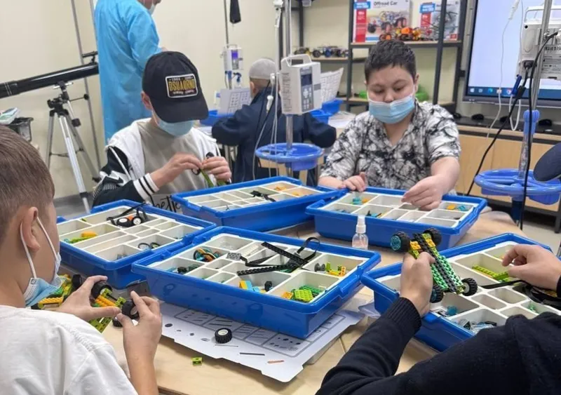 Children at an oncology centre building robots from Lego kits